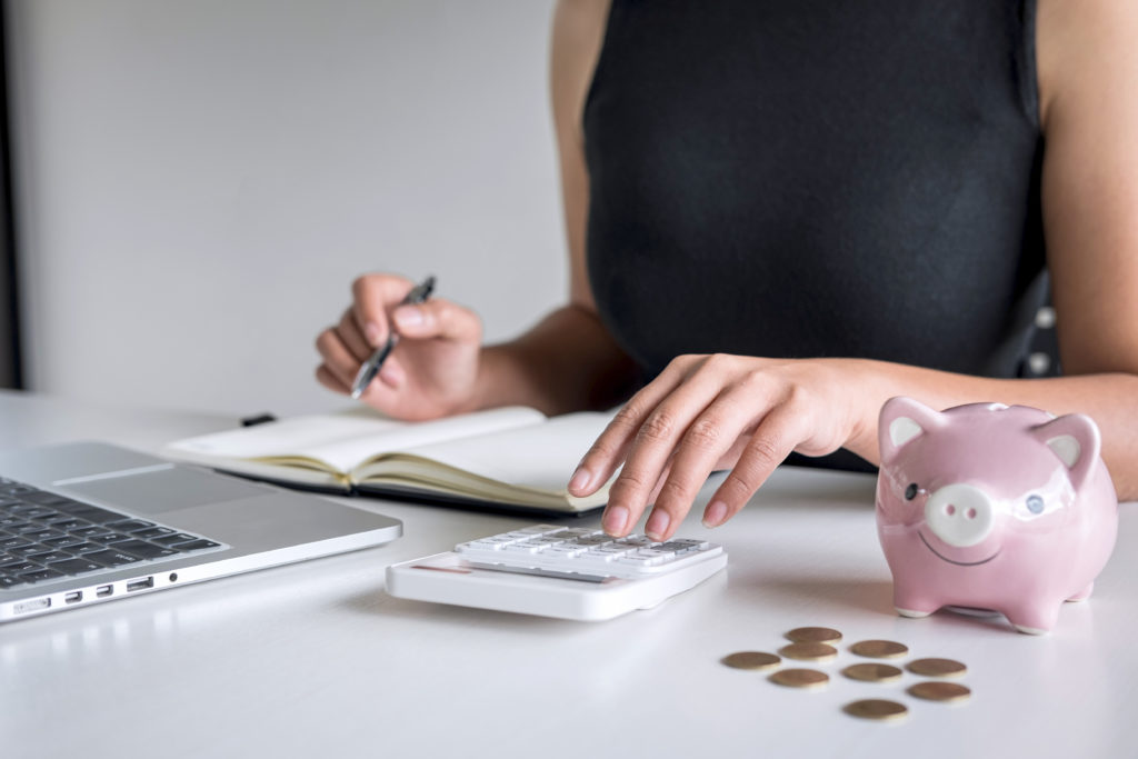 woman using coins in piggy bank and earning extra cash